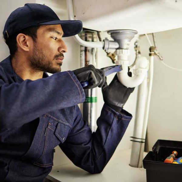 Plumbing, pipes and maintenance with man in kitchen for repair, industrial and inspection. Handyman.